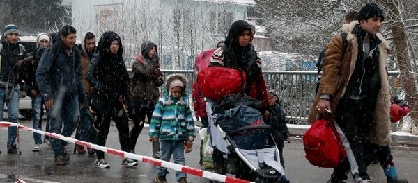 Migrants stay in queue during heavy snowfall before passing Austrian-German border in Wegscheid in Austria, near Passau November 22, 2015 Migrants stay in queue during heavy snowfall before passing Austrian-German border in Wegscheid in Austria, near Passau November 22, 2015 - Sputnik International