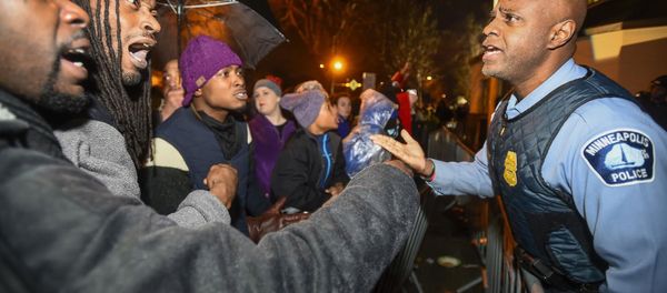 A police officer talks with demonstrators in front of a north Minneapolis police precinct during a protest in response of Sunday's shooting death of Jamar Clark by police officers in Minneapolis, Minnesota, November 18, 2015 A police officer talks with demonstrators in front of a north Minneapolis police precinct during a protest in response of Sunday's shooting death of Jamar Clark by police officers in Minneapolis, Minnesota, November 18, 2015 - Sputnik International