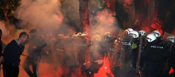 Montenegrin police officers are engulfed in smoke and flames as opposition supporters hurled torches on them during a protest in front of the Parliament building in Podgorica, Montenegro Saturday, Oct. 24, 2015. Police fired tear gas at opposition supporters who hurled fire bombs and torches to demand the resignation Prime Minister Milo Djukanovic's government which hopes to steer the Balkan country toward NATO membership later this year Montenegrin police officers are engulfed in smoke and flames as opposition supporters hurled torches on them during a protest in front of the Parliament building in Podgorica, Montenegro Saturday, Oct. 24, 2015. Police fired tear gas at opposition supporters who hurled fire bombs and torches to demand the resignation Prime Minister Milo Djukanovic's government which hopes to steer the Balkan country toward NATO membership later this year - Sputnik International