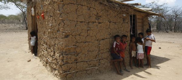 Wayuu indigenous children stand in the shade of their adobe home in Manaure, Colombia, Thursday, Sept. 10, 2015. Hunger exacerbated by a two-year-old drought is one of the biggest problems facing the Wayuu, a 600,000-strong ancestral tribe that’s caught in the middle of Venezuela’s crackdown on smuggling along its western border with Colombia - Sputnik International
