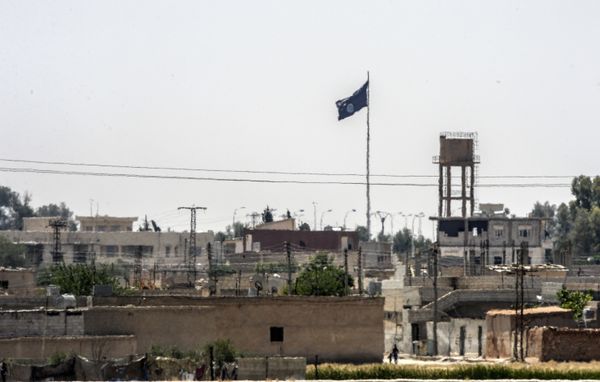 In a picture taken from Alcakale, Turkey, a flag of the Islamic State flutters amongst buildings in the center of the Syrian city Tal Abyad on June 13, 2015 - Sputnik International