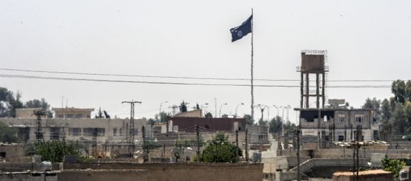 In a picture taken from Alcakale, Turkey, a flag of the Islamic State flutters amongst buildings in the center of the Syrian city Tal Abyad on June 13, 2015 - Sputnik International