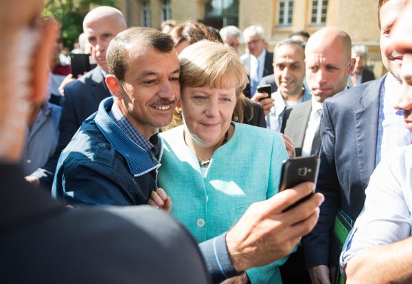 Asylum seeker (C, L) takes a selfie picture with German Chancellor Angela Merkel (C, R) following Merkel's visit at a branch of the Federal Office for Migration and Refugees and a camp for asylum-seekers in Berlin on September 10, 2015. Asylum seeker (C, L) takes a selfie picture with German Chancellor Angela Merkel (C, R) following Merkel's visit at a branch of the Federal Office for Migration and Refugees and a camp for asylum-seekers in Berlin on September 10, 2015. - Sputnik International