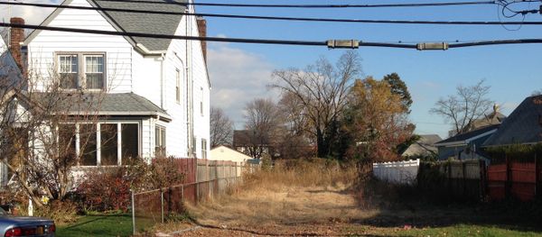 In this Nov. 25, 2015 photo, a lot stands empty in West Hempstead, N.Y., after the township had the home that once stood on it torn down. Homeowner Philip Williams says he went to Fort Lauderdale for the knee replacement in December, 2014. When he returned to the West Hempstead home in August 2015, his home was gone. - Sputnik International