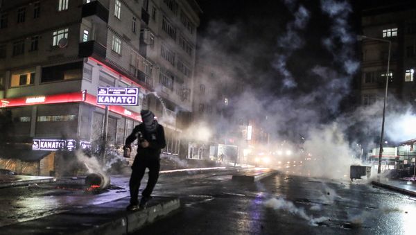 Police use teargas to disperse masked militants protesting the killing of Tahir Elci, a prominent lawyer and human rights defender, who faced a prison term on charges of supporting Kurdish rebels, in Istanbul, Turkey, late Saturday, Nov. 28, 2015 - Sputnik International