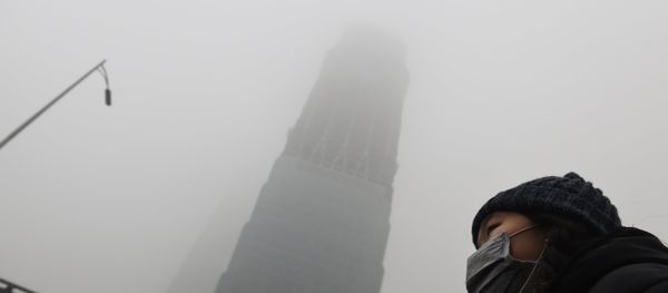 A woman waits for a bus below a skyscraper shrouded in smog on a heavily polluted day in Beijing on December 1, 2015 A woman waits for a bus below a skyscraper shrouded in smog on a heavily polluted day in Beijing on December 1, 2015 - Sputnik International