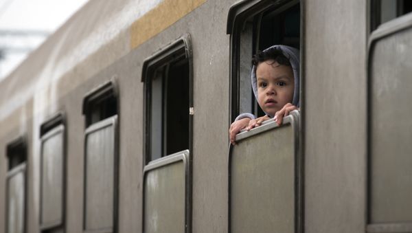 A child looks from a train carrying migrants in Kljuc Brdovecki, Croatia, near the Slovenian border, Friday, Oct. 23, 2015. - Sputnik International
