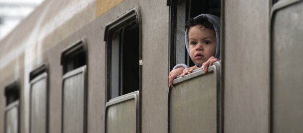 A child looks from a train carrying migrants in Kljuc Brdovecki, Croatia, near the Slovenian border, Friday, Oct. 23, 2015. A child looks from a train carrying migrants in Kljuc Brdovecki, Croatia, near the Slovenian border, Friday, Oct. 23, 2015. - Sputnik International