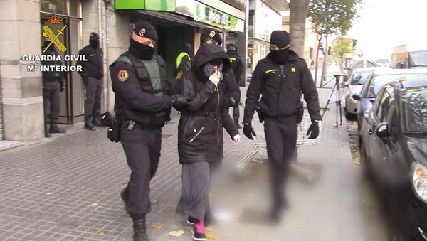 Spanish police escort a woman suspected of recruiting fighters for the Islamic State in Granollers, near Barcelona, in this handout picture from the Spanish Interior Ministry received November 28, 2015. Spain said it arrested three people on Saturday suspected of recruiting fighters for Islamic State in Syria and Iraq - Sputnik International