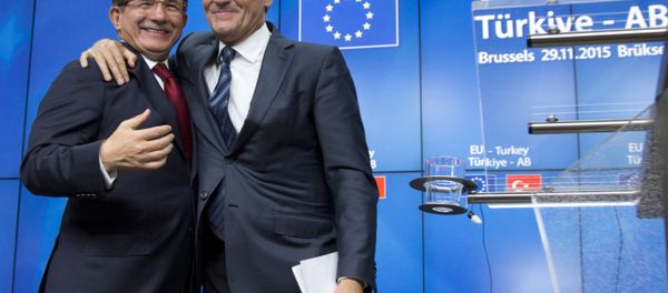 European Council President Donald Tusk, right, puts his arm on the shoulder of Turkish Prime Minister Ahmet Davutoglu after a media conference at an EU-Turkey summit in Brussels on Sunday, Nov. 29, 2015. - Sputnik International