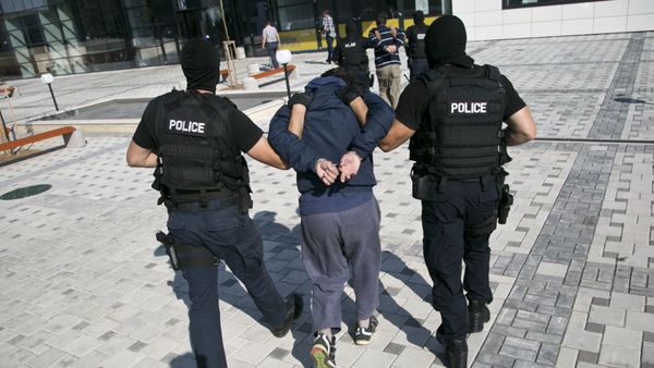 Kosovo police officers escort unidentified Kosovo Albanian men who are suspects in a terror plot, to a court in Kosovo's capital Pristina, Sunday, July 12, 2015 - Sputnik International