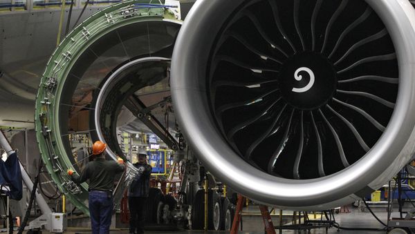Worker maneuver the cover of a engine into place on a Boeing 777 jet at the company's manufacturing plant, Monday, Feb. 14, 2011, in Everett, Wash. - Sputnik International