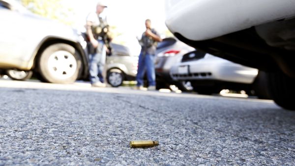 A spent cartrdige lies on the ground as police officers secure the area after at least one person opened fire at a social services agency in San Bernardino. - Sputnik International