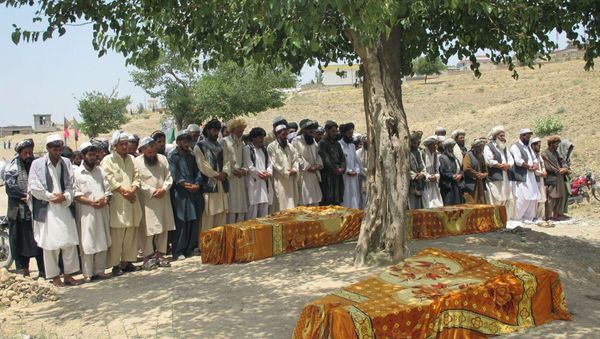 Afghans offer prayers over the covered coffins during a burial ceremony in Khost, Afghanistan. Afghans offer prayers over the covered coffins during a burial ceremony in Khost, Afghanistan. - Sputnik International