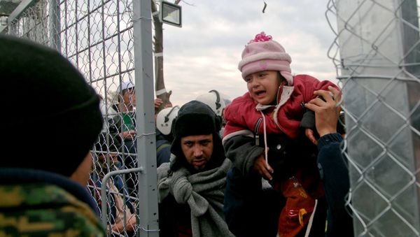 A migrant is child carried into Macedonia, near the southern Macedonian town of Gevgelija, Friday, Dec. 4, 2015. - Sputnik International