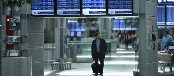 A passengers walks under information boards at the airport in Duesseldorf, Germany A passengers walks under information boards at the airport in Duesseldorf, Germany - Sputnik International