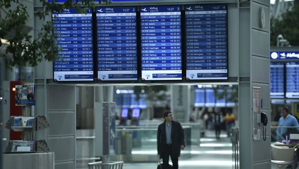 A passengers walks under information boards at the airport in Duesseldorf, Germany A passengers walks under information boards at the airport in Duesseldorf, Germany - Sputnik International