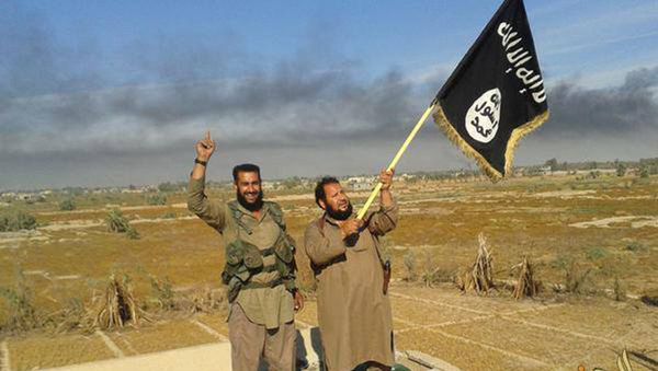 Islamic State militant waves his group's flag as he and another celebrate in Fallujah, Iraq, west of Baghdad - Sputnik International