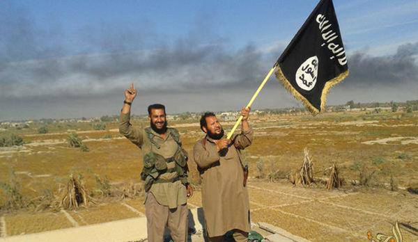 Islamic State militant waves his group's flag as he and another celebrate in Fallujah, Iraq, west of Baghdad Islamic State militant waves his group's flag as he and another celebrate in Fallujah, Iraq, west of Baghdad - Sputnik International