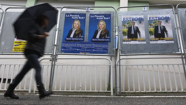 A woman walks past electoral posters of far right National Front party regional leader for southern France, Marion Marechal-Le Pen, left, and French right-wing party Les Republicains candidate Christian Estrosi, in Nice, southeastern France, Saturday, Dec. 5, 2015.  - Sputnik International