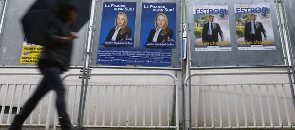 A woman walks past electoral posters of far right National Front party regional leader for southern France, Marion Marechal-Le Pen, left, and French right-wing party Les Republicains candidate Christian Estrosi, in Nice, southeastern France, Saturday, Dec. 5, 2015. - Sputnik International