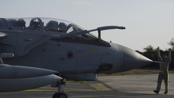 A ground crewman directs a Royal Air Force Tornado along the tarmac of a British air base in Akrotiri, Cyprus, after returning from an airstrike against Islamic State group targets in Syria Thursday, Dec. 3, 2015 - Sputnik International