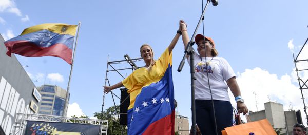 Lilian Tintori (L), wife of jailed Venezuelan opposition leader Leopoldo Lopez, holds up the hand of a supporter during a rally in Caracas - Sputnik International