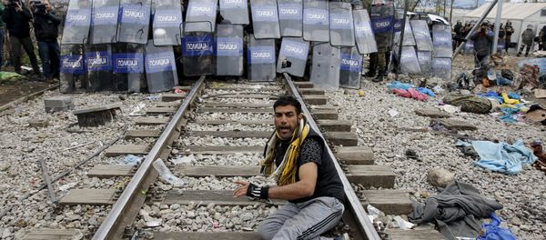 A stranded migrant reacts in front of a Macedonian police cordon as they clash after a migrant was injured when he climbed on top of a train wagon, near the village of Idomeni, Greece, November 28, 2015. - Sputnik International