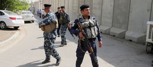 Iraqi security forces stand guard while released Turkish workers arrive at the Turkish Embassy in Baghdad, Iraq, Wednesday, Sept. 30, 2015 - Sputnik International