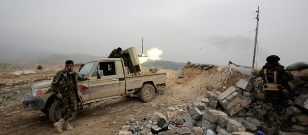 Kurdish peshmerga fighter fires a weapon towards positions of the Islamic State group who are 500 meters or half a mile away, overlooking the strategic town of Sinjar, northern Iraq - Sputnik International