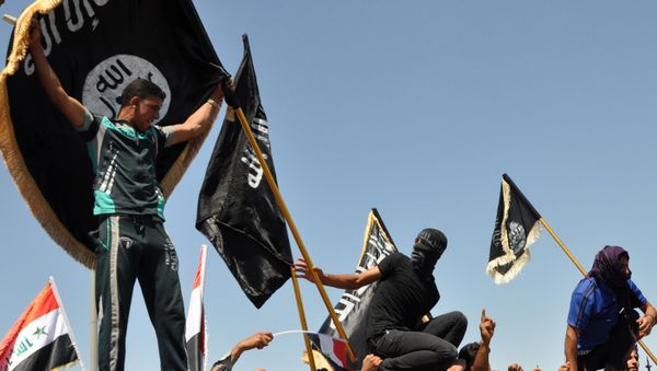 FILE - Masked Sunni protesters wave Islamist flags while others chant slogans at an anti-government rally in Fallujah, Iraq - Sputnik International