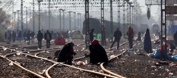 Migrants and refugees wait to cross the Greek-Macedonian border near Idomeni on December 7, 2015 - Sputnik International