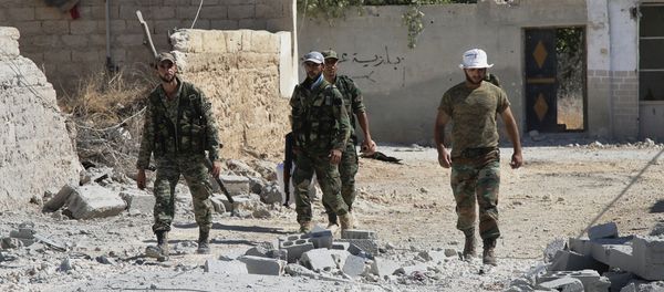 Syrian army soldiers walk in Achan, Hama province, Syria - Sputnik International