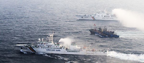 A picture taken on December 21 from a South Korean helicopter shows 12 Chinese fishing boats (C) banded together with ropes to thwart an attempt by South Korean coastguard ships to stop their alleged illegal fishing in the Yellow Sea off the coast of South Korea A picture taken on December 21 from a South Korean helicopter shows 12 Chinese fishing boats (C) banded together with ropes to thwart an attempt by South Korean coastguard ships to stop their alleged illegal fishing in the Yellow Sea off the coast of South Korea - Sputnik International