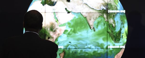 A conference attendee looks at a projection of the Earth on the opening day of the COP 21 United Nations conference on climate change, on November 30, 2015 in Le Bourget - Sputnik International