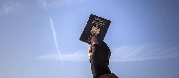 A refugee holds up his Iraqi passport at the port of Molyvos after a rescue operation by members of the Frontex, European Border Protection Agency, from Portugal near the northeastern Greek island of Lesbos, Tuesday, Dec. 8, 2015. A refugee holds up his Iraqi passport at the port of Molyvos after a rescue operation by members of the Frontex, European Border Protection Agency, from Portugal near the northeastern Greek island of Lesbos, Tuesday, Dec. 8, 2015. - Sputnik International
