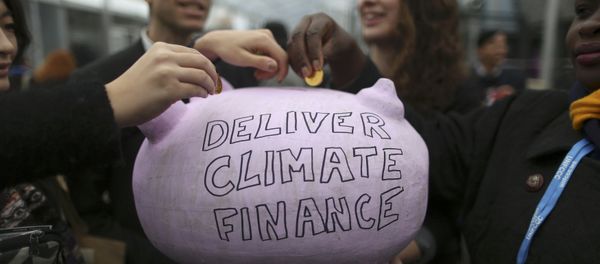 Participants contribute coins into a piggy bank during the World Climate Change Conference 2015 (COP21) at Le Bourget, near Paris, France, December 10, 2015 - Sputnik International
