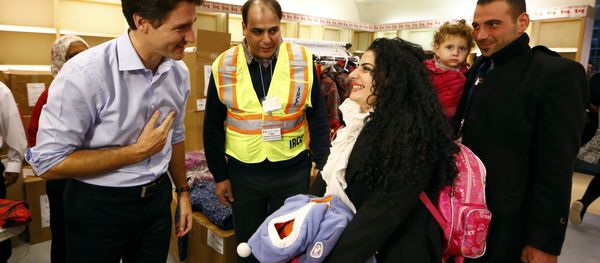 Syrian refugees are greeted by Canada's Prime Minister Justin Trudeau (L) on their arrival from Beirut at the Toronto Pearson International Airport in Mississauga, Ontario, Canada December 11, 2015 - Sputnik International