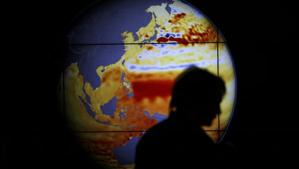 A woman walks past a map showing the elevation of the sea in the last 22 years during the World Climate Change Conference 2015 (COP21) at Le Bourget, near Paris, France, December 11, 2015 - Sputnik International