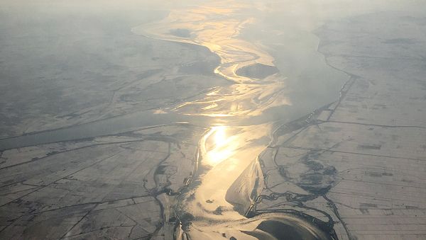 In this Friday, Nov. 27, 2015, photo, which was taken from an airplane approaching Pyongyang, light from the evening sun is cast on a river flowing through snow covered farm fields in North Korea In this Friday, Nov. 27, 2015, photo, which was taken from an airplane approaching Pyongyang, light from the evening sun is cast on a river flowing through snow covered farm fields in North Korea - Sputnik International