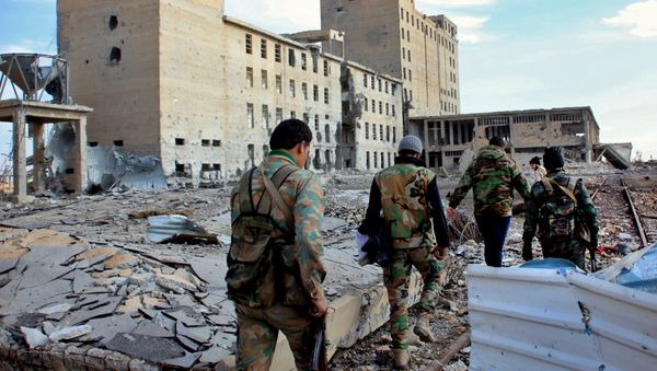 Syrian army soldiers patrol near a building previously used for storing seeds in the countryside of Deir Hafer, a former bastion of Daesh, near the northern Syrian city of Aleppo on December 2, 2015 - Sputnik International