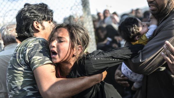 Syrians fleeing the war rush through broken down border fences to enter Turkish territory illegally, near the Turkish border crossing at Akcakale in Sanliurfa province on June 14, 2015. - Sputnik International