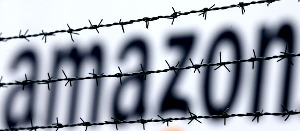 The internet trader Amazon logo is seen behind barbed wire at the company's logistic center in Rheinberg,Germany, Tuesday, Feb.19, 2013. The internet trader Amazon logo is seen behind barbed wire at the company's logistic center in Rheinberg,Germany, Tuesday, Feb.19, 2013. - Sputnik International