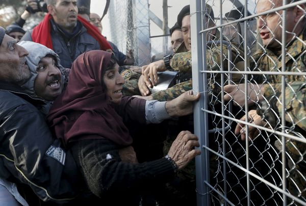 Syrian refugees struggle to enter Macedonia through a narrow border crossing as Macedonian policemen try to shut a metal gate near to the Greek village of Idomeni December 4, 2015. - Sputnik International