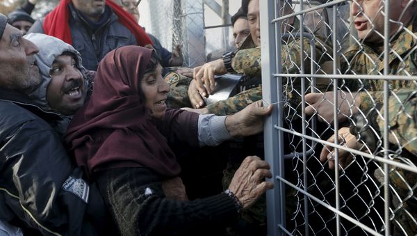 Syrian refugees struggle to enter Macedonia through a narrow border crossing as Macedonian policemen try to shut a metal gate near to the Greek village of Idomeni December 4, 2015 Syrian refugees struggle to enter Macedonia through a narrow border crossing as Macedonian policemen try to shut a metal gate near to the Greek village of Idomeni December 4, 2015 - Sputnik International