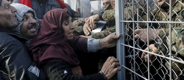 Syrian refugees struggle to enter Macedonia through a narrow border crossing as Macedonian policemen try to shut a metal gate near to the Greek village of Idomeni December 4, 2015 Syrian refugees struggle to enter Macedonia through a narrow border crossing as Macedonian policemen try to shut a metal gate near to the Greek village of Idomeni December 4, 2015 - Sputnik International