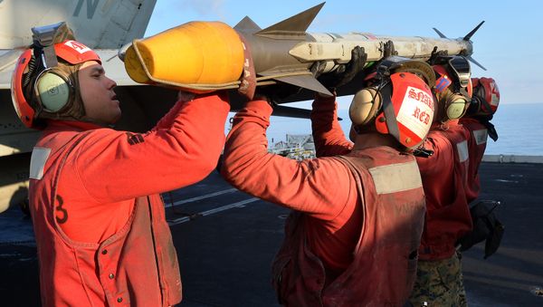 US Navy personnel load rocket on a F/A-18E Super Hornet on the flight deck of the USS Nimitz (CVN 68) aircraft carrier in the Mediterranean Sea on October 25, 2013 - Sputnik International