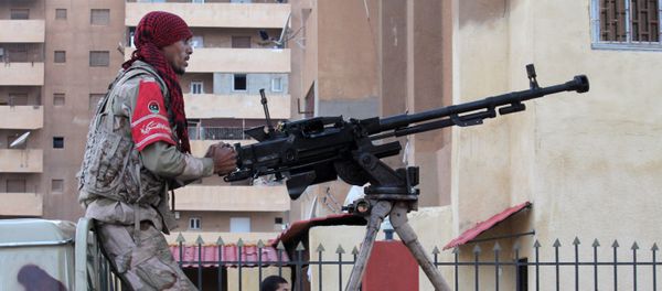 A member of the pro-government Libyan forces stands on top of an armed vehicle during a attack on districts held by Islamist militias - Sputnik International