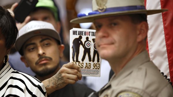 California Highway Patrol Officer J. Nelson stands outside the office of Gov. Jerry Brown as protestors shouting black lives matter block the hallway demanding passage of AB953, Wednesday, Sept. 2, 2015, in Sacramento,Calif. - Sputnik International