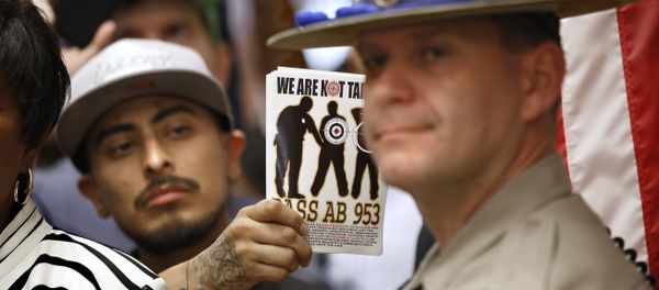 California Highway Patrol Officer J. Nelson stands outside the office of Gov. Jerry Brown as protestors shouting black lives matter block the hallway demanding passage of AB953, Wednesday, Sept. 2, 2015, in Sacramento,Calif. - Sputnik International